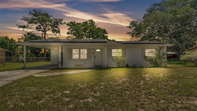 815 Everett St, Lake Alfred, FL 33850 - view of front facade with concrete driveway, a carport, roof mounted solar panels, and stucco siding