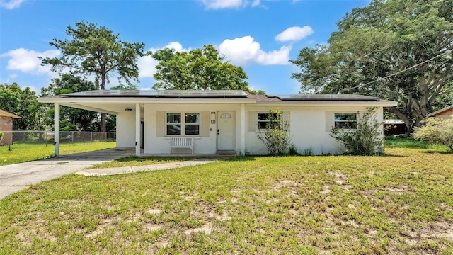 815 Everett St, Lake Alfred, FL 33850 - view of front of property featuring driveway, stucco siding, solar panels, and an attached carport