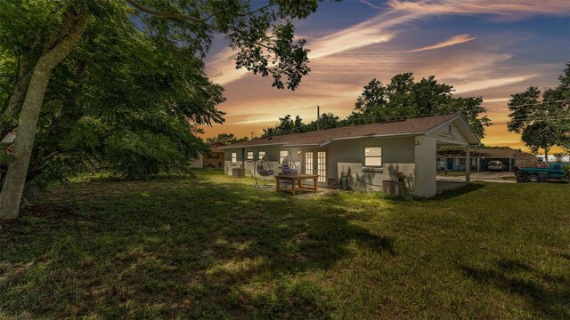 815 Everett St, Lake Alfred, FL 33850 - back of property at dusk featuring a yard