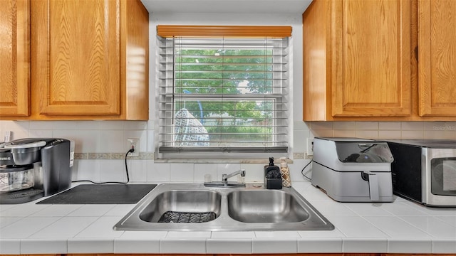 815 Everett St, Lake Alfred, FL 33850 - kitchen with stainless steel microwave, tile countertops, and decorative backsplash