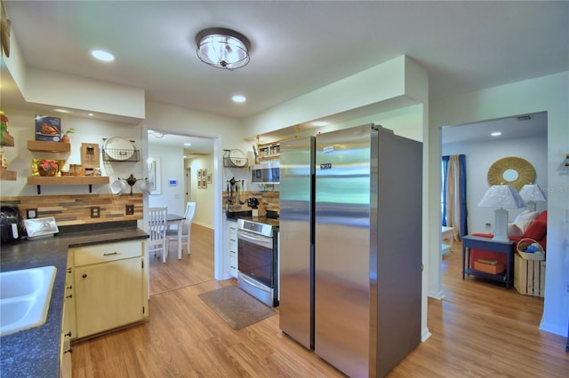 2814 Grapefruit Dr, Auburndale, FL 33823 - kitchen with appliances with stainless steel finishes, dark countertops, light wood-style floors, backsplash, and recessed lighting