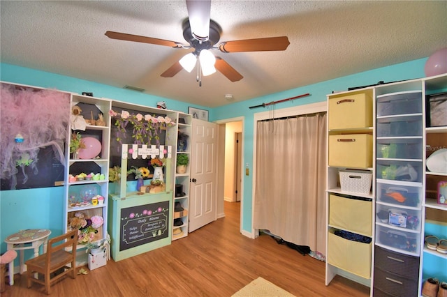 2814 Grapefruit Dr, Auburndale, FL 33823 - bedroom with wood finished floors, a textured ceiling, and a ceiling fan