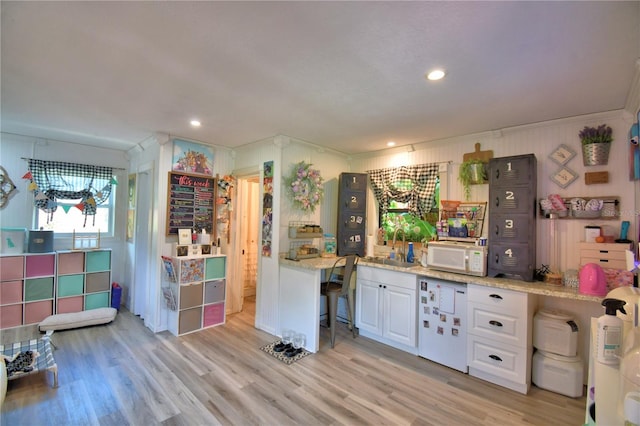 2814 Grapefruit Dr, Auburndale, FL 33823 - kitchen featuring white cabinets, white microwave, light wood-style flooring, light stone counters, and recessed lighting