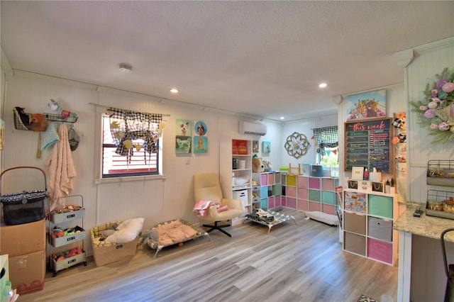 2814 Grapefruit Dr, Auburndale, FL 33823 - playroom featuring wood finished floors, a wall mounted air conditioner, recessed lighting, and a textured ceiling