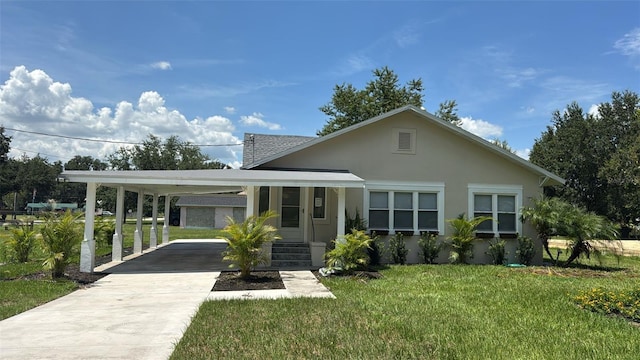 713 4th St NE, Fort Meade, FL 33841 - view of front of house featuring concrete driveway, a carport, a front yard, and stucco siding