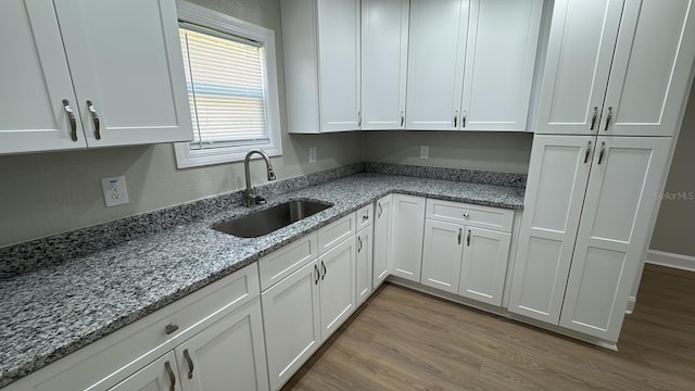713 4th St NE, Fort Meade, FL 33841 - kitchen featuring light wood finished floors, white cabinets, and light stone countertops