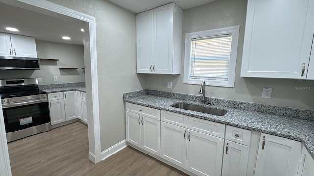 713 4th St NE, Fort Meade, FL 33841 - kitchen with appliances with stainless steel finishes, white cabinets, and a textured wall