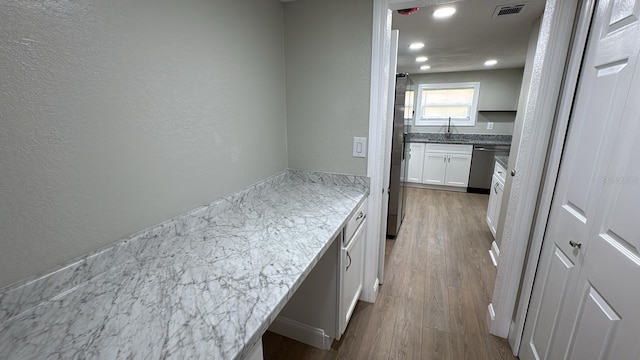 713 4th St NE, Fort Meade, FL 33841 - kitchen with appliances with stainless steel finishes, wood finished floors, white cabinets, recessed lighting, and a textured wall