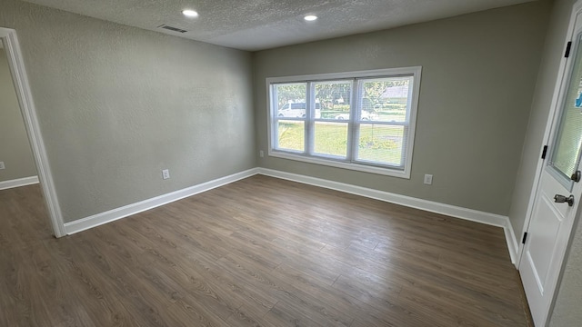 713 4th St NE, Fort Meade, FL 33841 - spare room with a textured ceiling, dark wood-style flooring, and recessed lighting