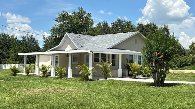 713 4th St NE, Fort Meade, FL 33841 - farmhouse-style home with a front yard, stucco siding, covered porch, and roof with shingles