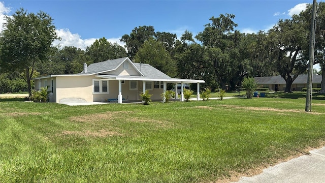 713 4th St NE, Fort Meade, FL 33841 - view of front of house featuring a porch, a front lawn, and view of scattered trees