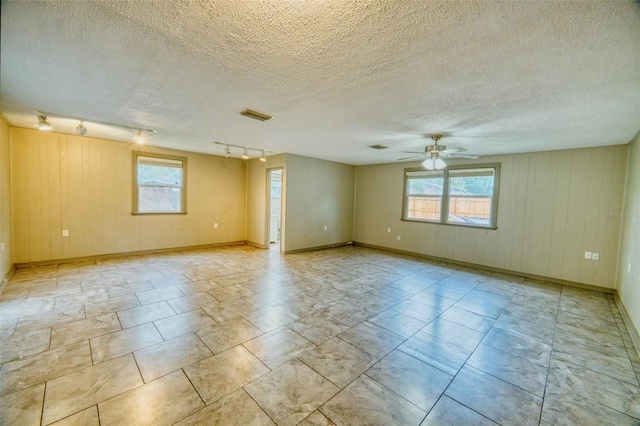 415 Boger Blvd N, Lakeland, FL 33803 - spare room with plenty of natural light, ceiling fan, rail lighting, a textured ceiling, and wooden walls