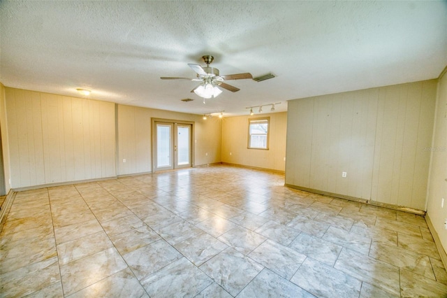 415 Boger Blvd N, Lakeland, FL 33803 - unfurnished room featuring a ceiling fan, rail lighting, a textured ceiling, wooden walls, and marble look tiles