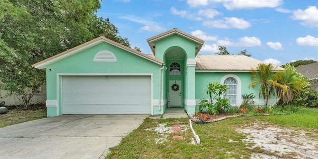 912 Whisper Lake Dr, Winter Haven, FL 33880 - view of front facade with concrete driveway, a garage, stucco siding, and a metal roof