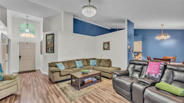 912 Whisper Lake Dr, Winter Haven, FL 33880 - living room with a chandelier, light wood-style flooring, a textured ceiling, and high vaulted ceiling