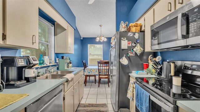 912 Whisper Lake Dr, Winter Haven, FL 33880 - kitchen featuring stainless steel appliances, light countertops, a chandelier, light tile patterned floors, and decorative light fixtures