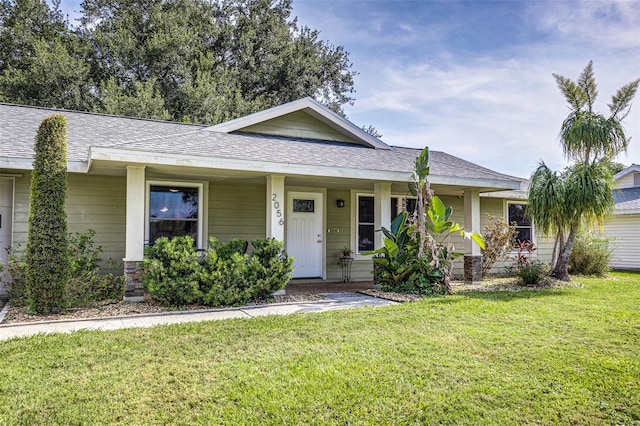 2056 Broken Arrow Trl N, Lakeland, FL 33813 - view of front of house featuring a front yard, a shingled roof, and a porch