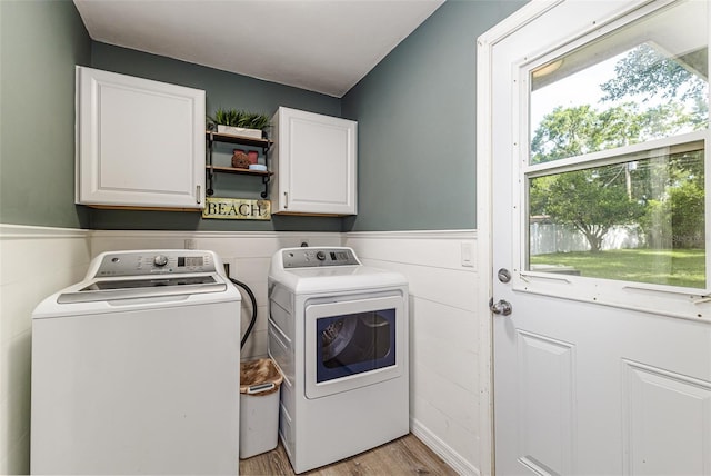 2056 Broken Arrow Trl N, Lakeland, FL 33813 - laundry room featuring cabinet space, washing machine and clothes dryer, light wood-style flooring, and a wainscoted wall