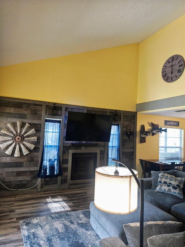 985 Whisper Lk, Winter Haven, FL 33880 - living area featuring wood finished floors, vaulted ceiling, a fireplace, and a textured ceiling