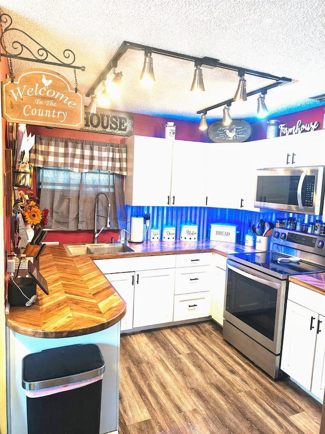985 Whisper Lk, Winter Haven, FL 33880 - kitchen featuring appliances with stainless steel finishes, wood counters, white cabinetry, a textured ceiling, and track lighting