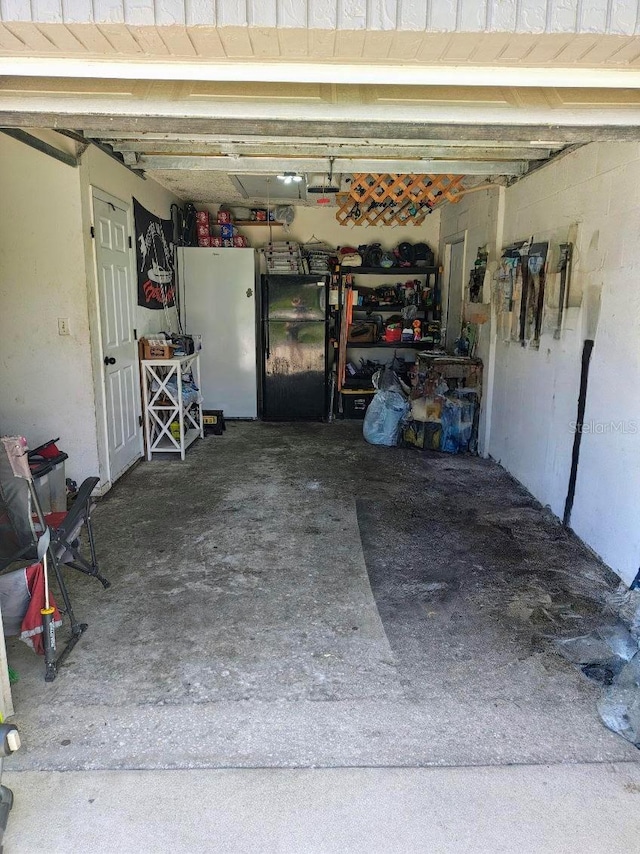 985 Whisper Lk, Winter Haven, FL 33880 - garage featuring freestanding refrigerator and a garage door opener