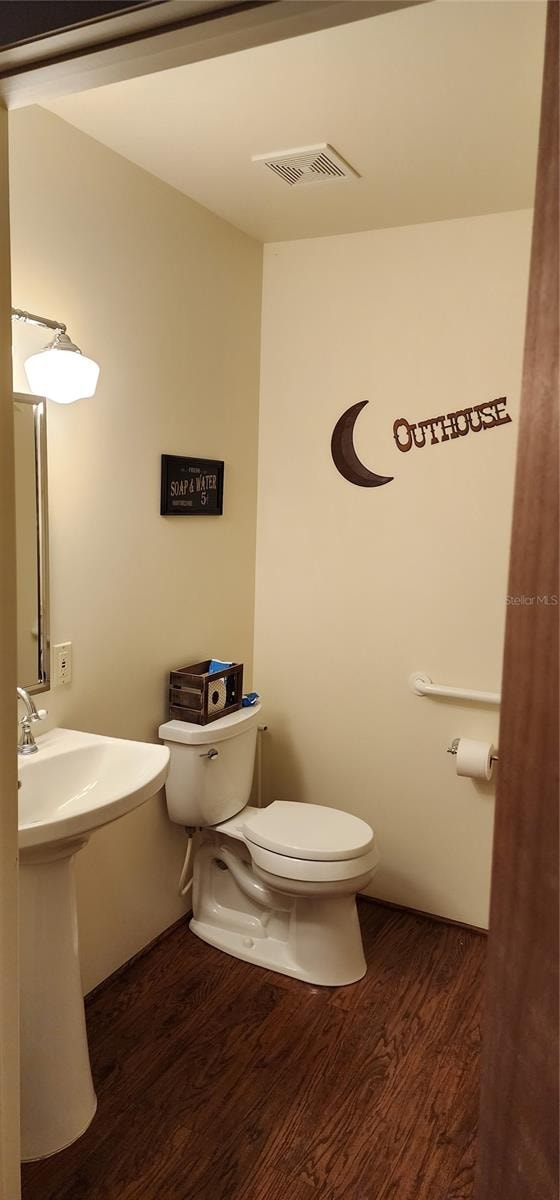 bathroom featuring toilet and wood-type flooring