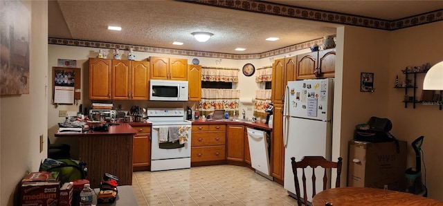 kitchen featuring white appliances, a textured ceiling, and sink