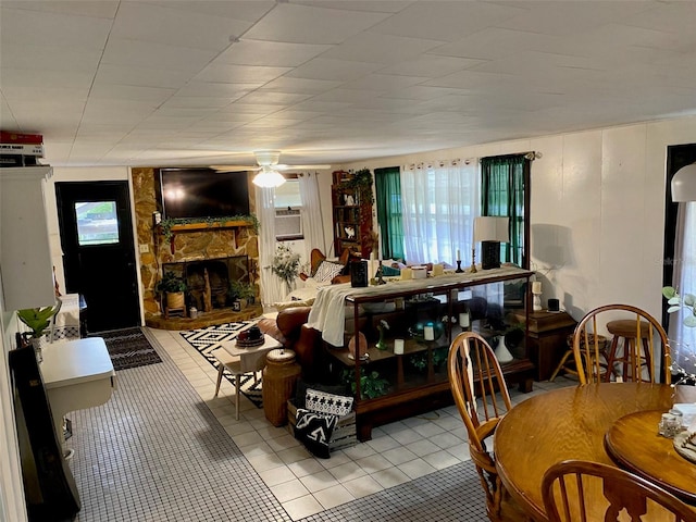 living room with light tile flooring, ceiling fan, and a fireplace