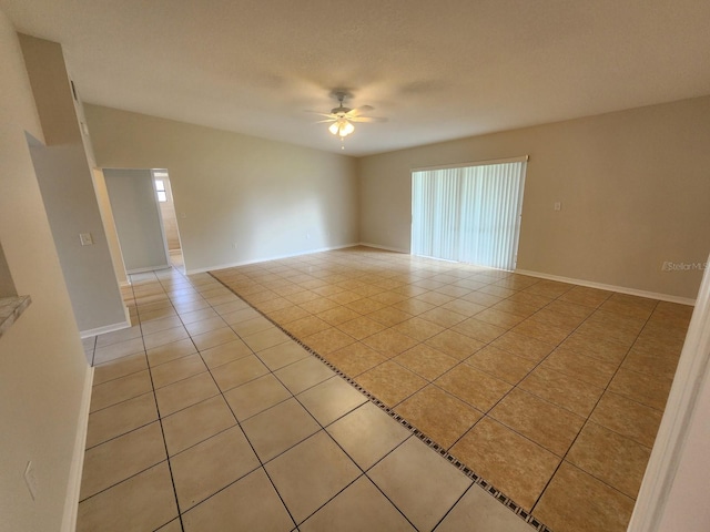 spare room with light tile flooring and ceiling fan