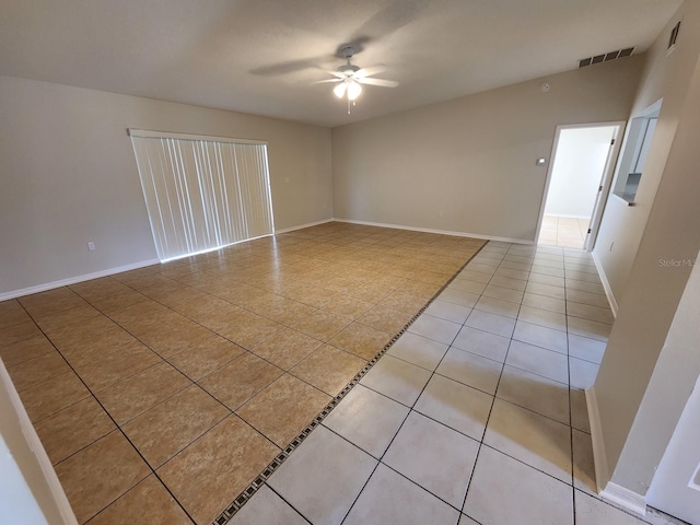 spare room featuring light tile flooring and ceiling fan