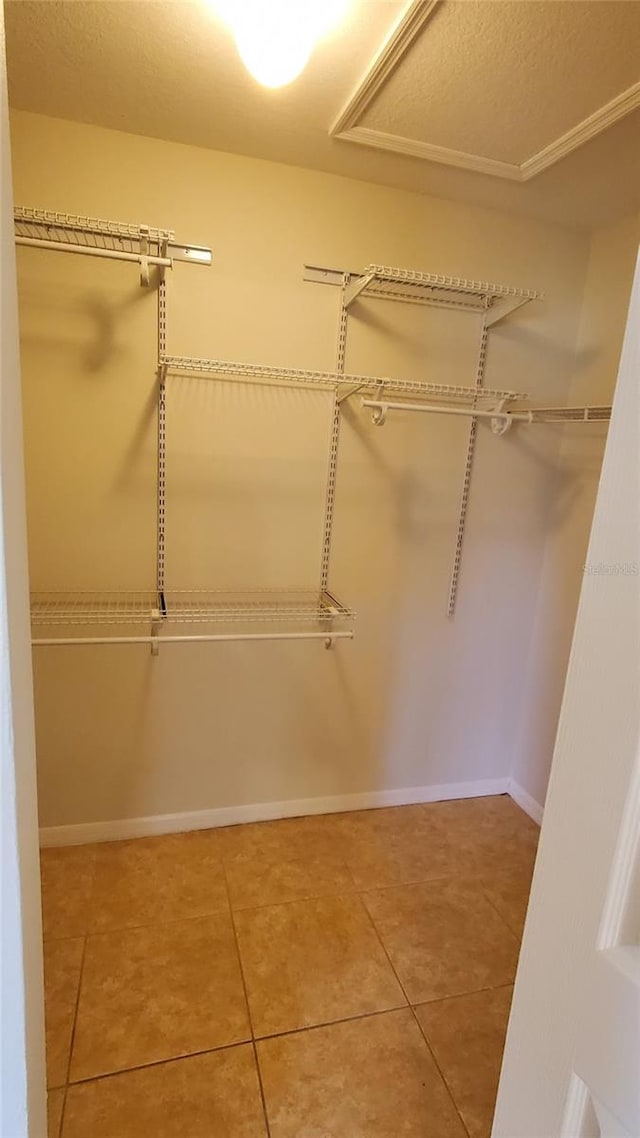 walk in closet featuring light tile flooring