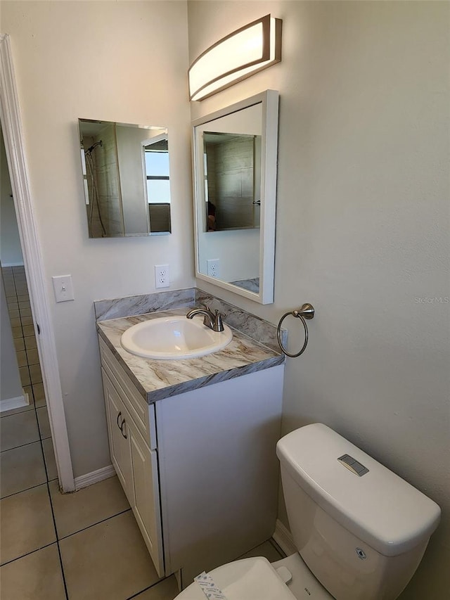 bathroom with tile floors, vanity with extensive cabinet space, and toilet