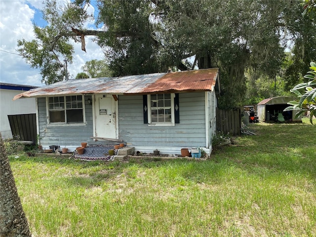 view of front of house featuring a front yard and a shed