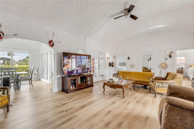 living room with french doors, a textured ceiling, ceiling fan, and light hardwood / wood-style flooring