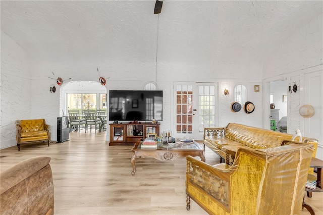 living room with a textured ceiling and light wood-type flooring