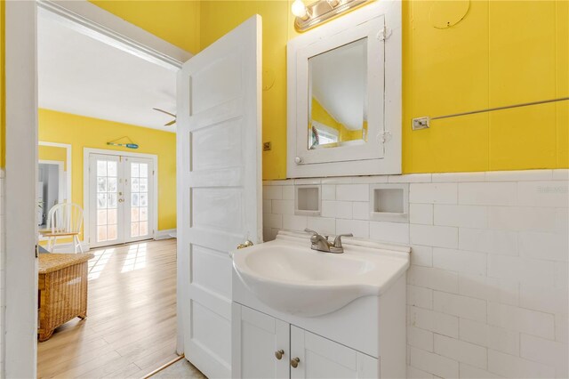 bathroom with vanity, tasteful backsplash, french doors, and hardwood / wood-style flooring