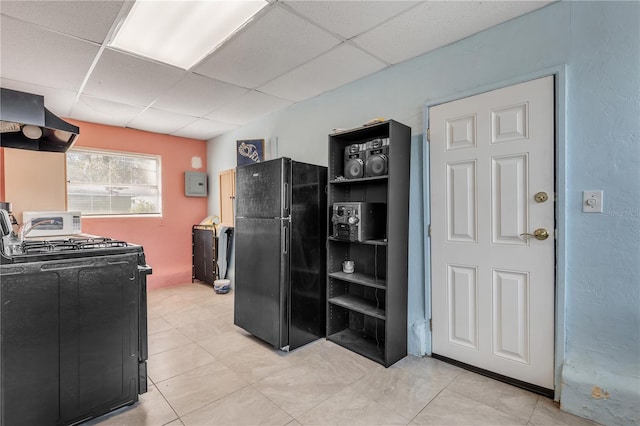 kitchen with a drop ceiling, light tile floors, and black appliances