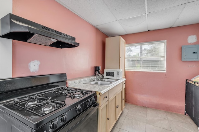 kitchen with light tile flooring, black stove, a drop ceiling, light brown cabinetry, and sink