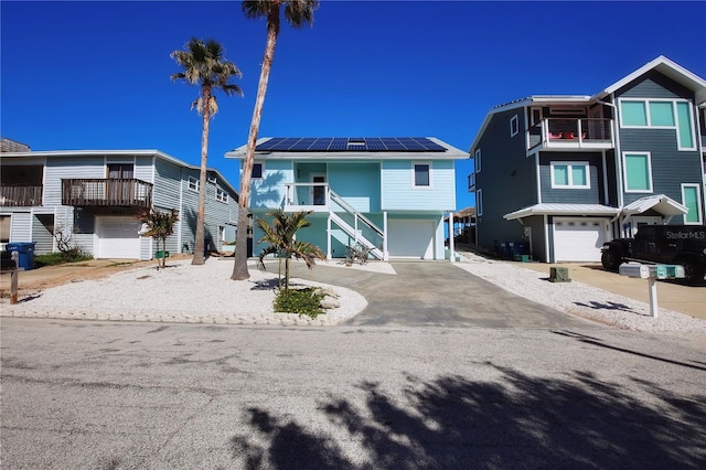 view of front of house featuring a balcony, a garage, and solar panels