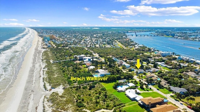 drone / aerial view featuring a water view and a view of the beach