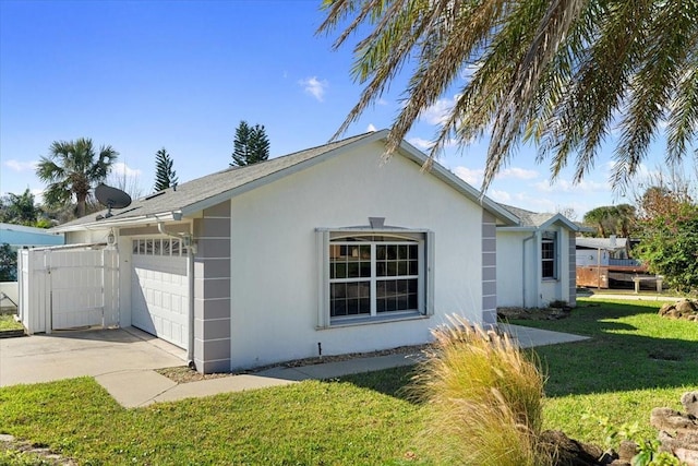 view of side of home featuring a garage and a yard