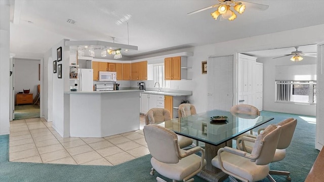 tiled dining space with sink, ceiling fan, and a wealth of natural light