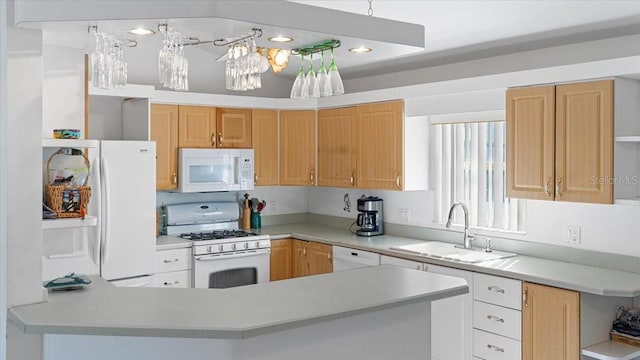 kitchen with light brown cabinetry, kitchen peninsula, white appliances, and sink