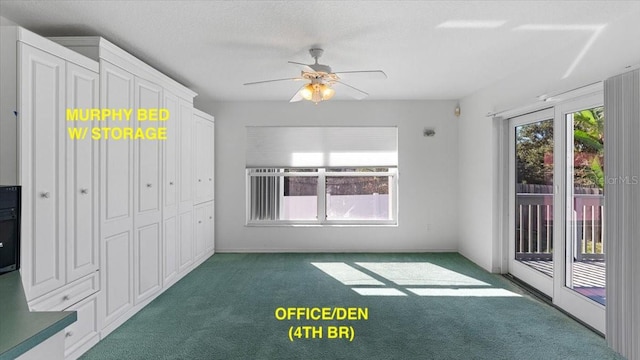 interior space with ceiling fan and dark carpet