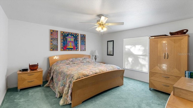 bedroom with a textured ceiling, ceiling fan, and dark carpet