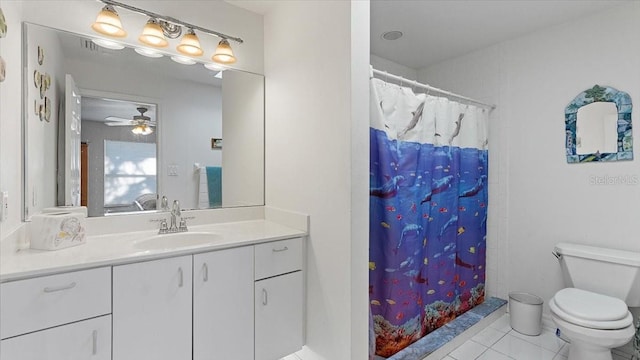 bathroom with tile flooring, vanity with extensive cabinet space, ceiling fan, and toilet