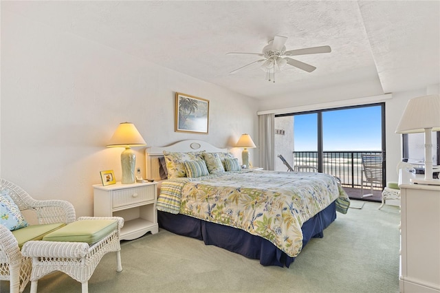 carpeted bedroom featuring access to exterior, ceiling fan, and a textured ceiling