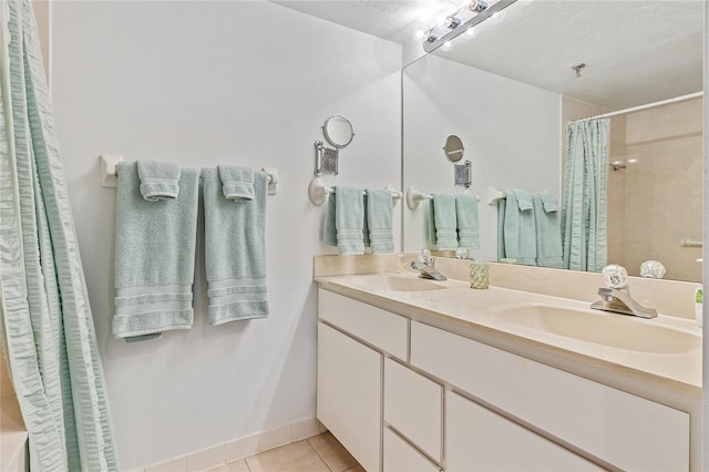 bathroom with vanity with extensive cabinet space, tile flooring, double sink, and a textured ceiling