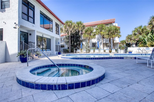 view of pool featuring a community hot tub and a patio