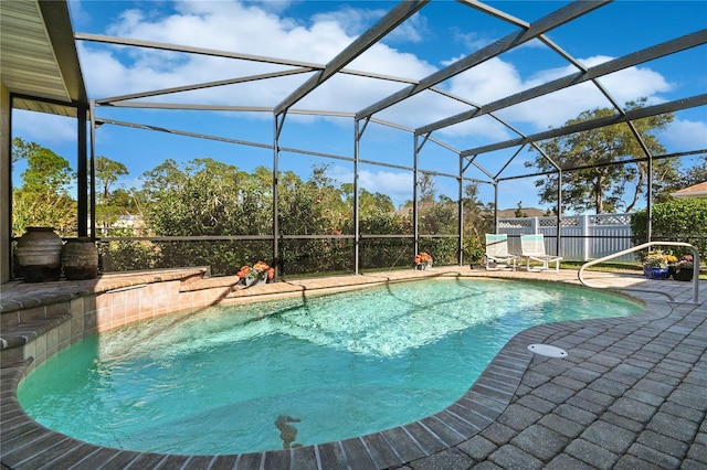 view of swimming pool featuring glass enclosure and a patio area